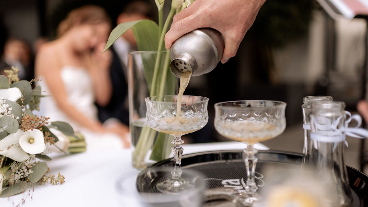 Getränk wird in Hochzeitskessel gegossen mit Blumen auf dem Tisch