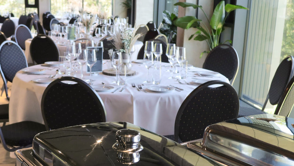 STAGE im PLICANA in Kronau mit runden weiß dekorierten Tischen und schwarzen Stühlen