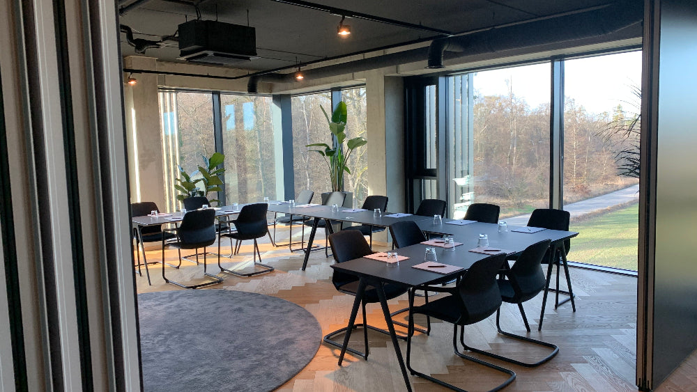 Schwarze Tischreihe für ein Meeting im Dine und Ausblick aus den Glaswänden