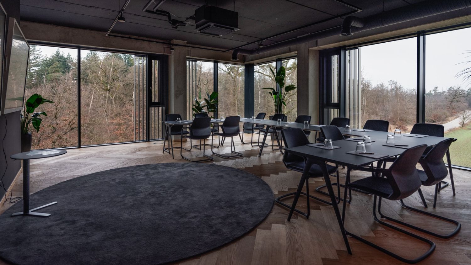 DINE im PLICANA in Kronau mit schwarzen Stühlen, Tischen und großen Bildschirmen an der Wand