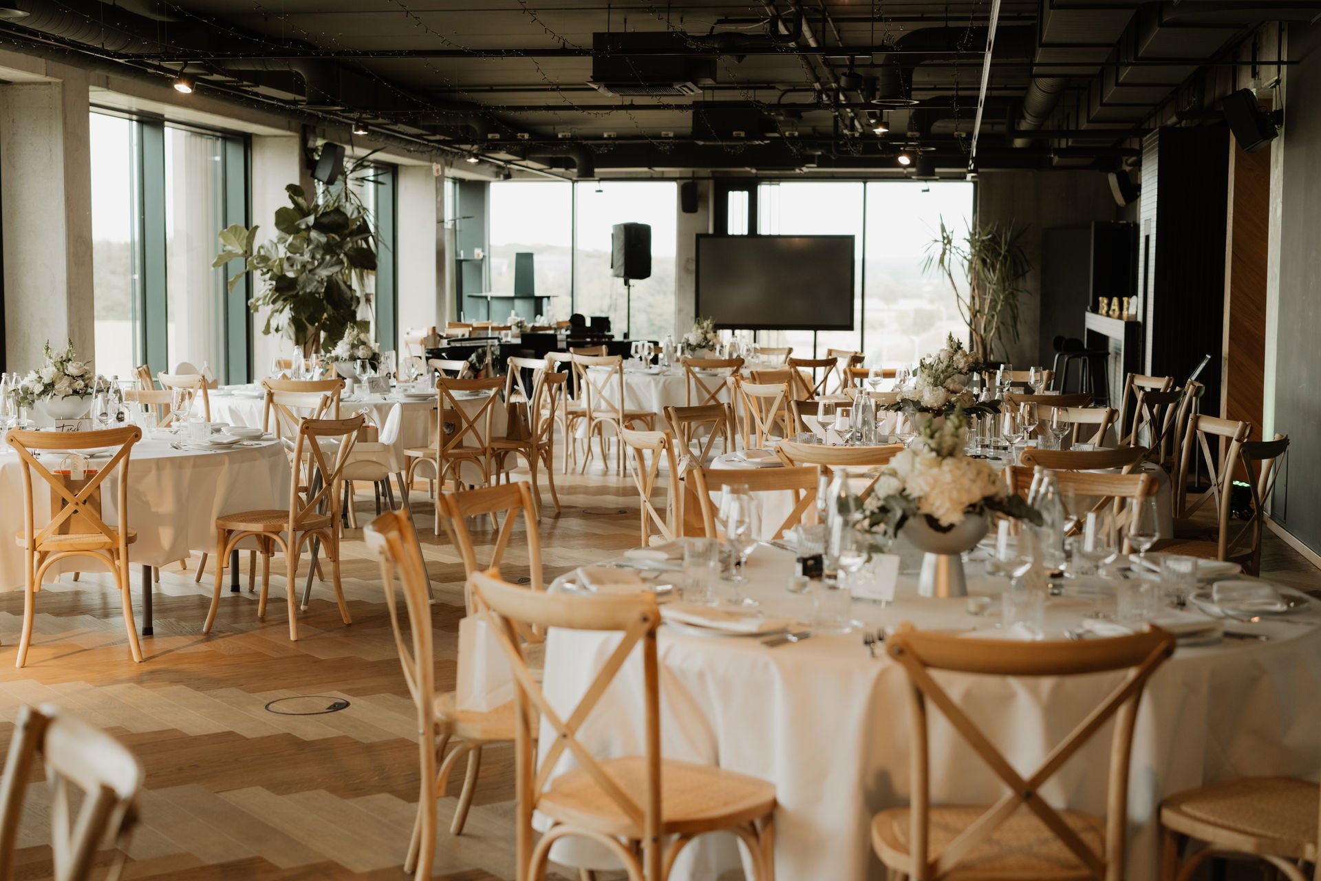 Stage PLICANA mit Holzstühlen und weißen Tischen