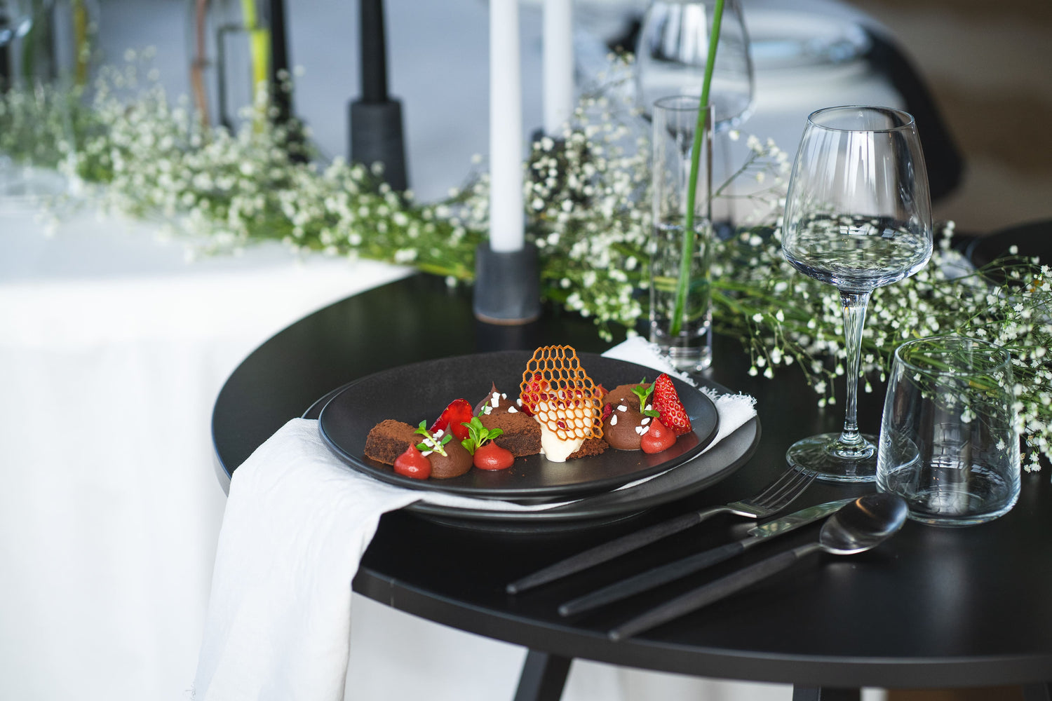 Schokoladen-Dessert auf schwarzem runden Tisch mit weißer Deko