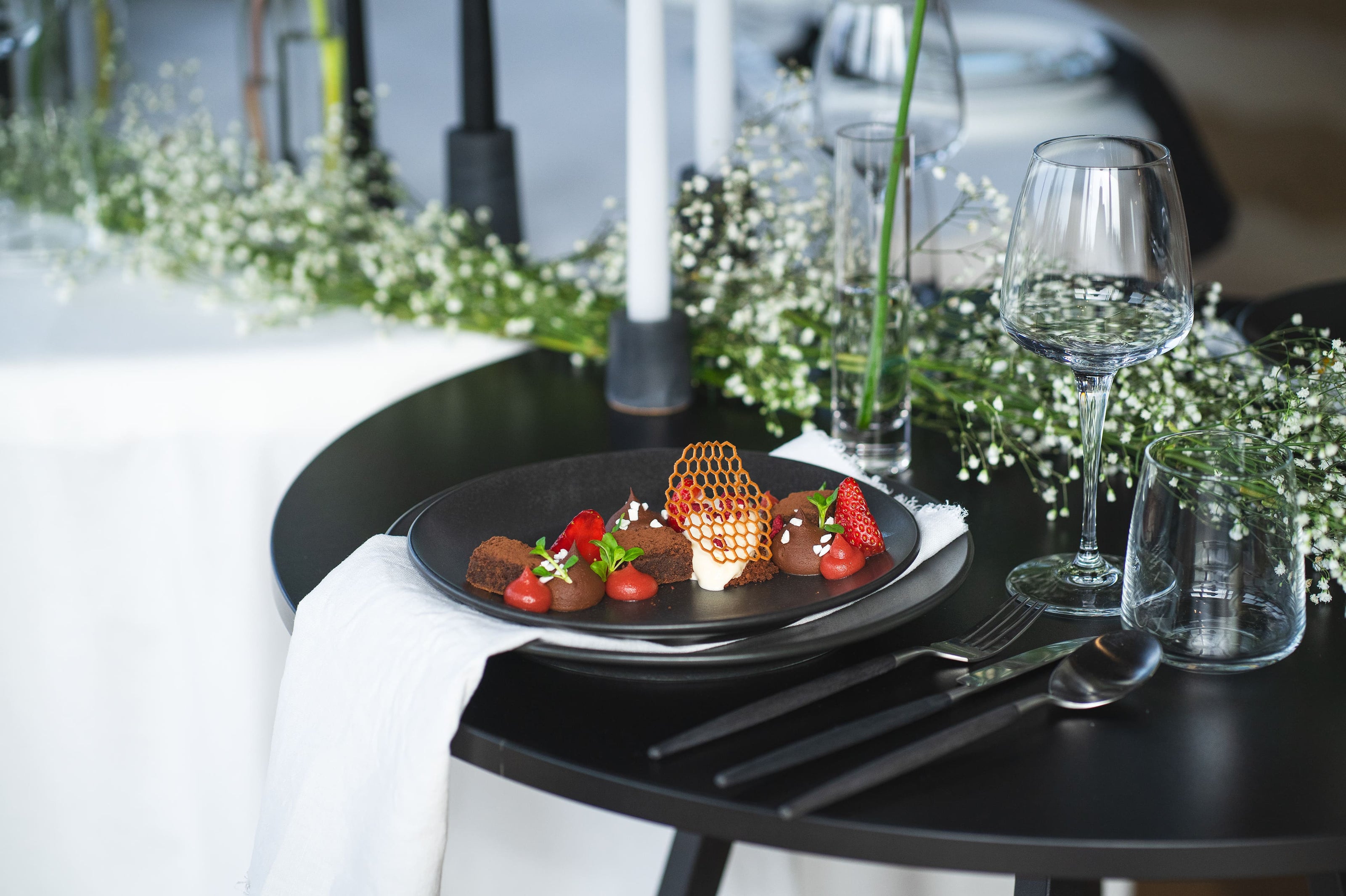 Schokoladen-Dessert auf schwarzem runden Tisch mit weißer Deko