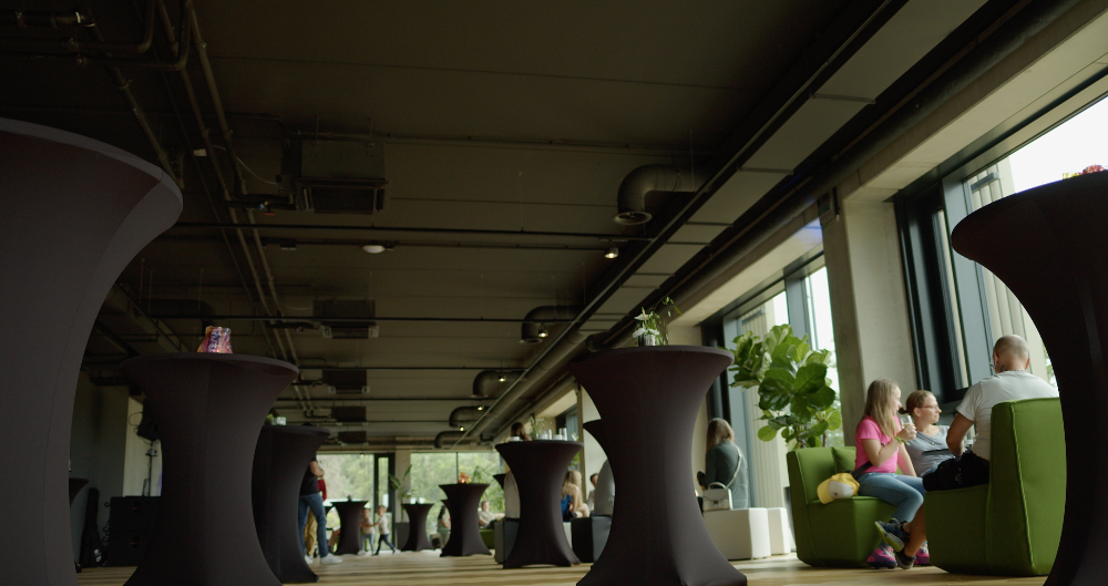 Schwarze Stehtische und grüne Sofas auf dem STAGE des PLICANA in Kronau