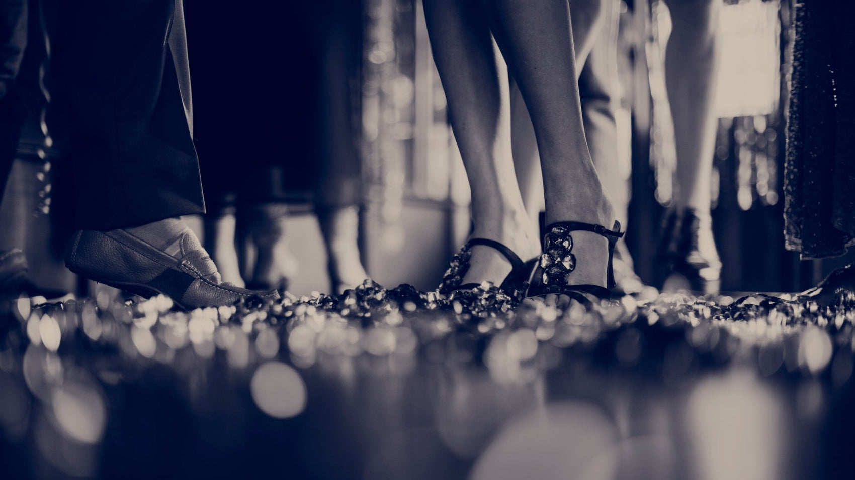 Beine bei Feier der Modenschau mit High Heels und Lederschuhen und Konfetti auf dem Boden